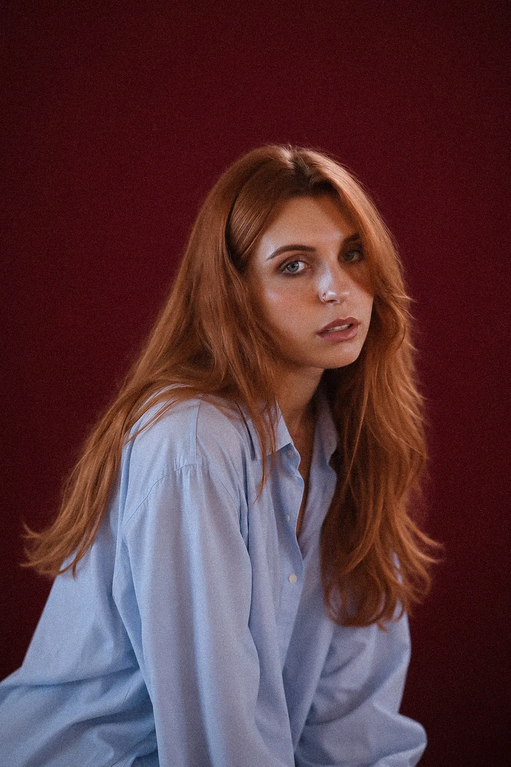 Portrait of Anastasiia Preston against a deep burgundy backdrop